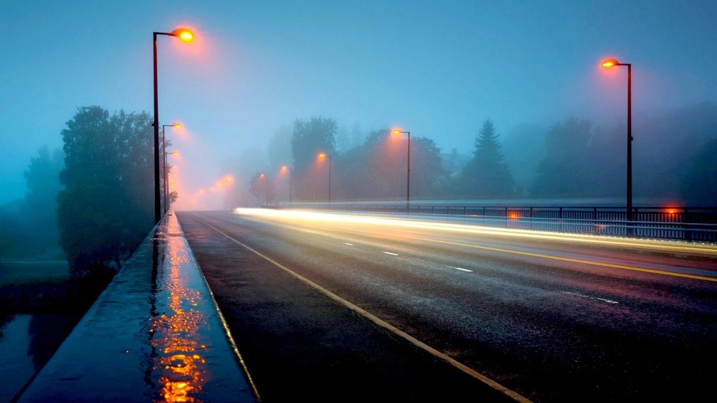 a highway bridge in a foggy rainy night
