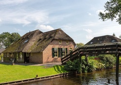 thatched roof house by a beautiful creek