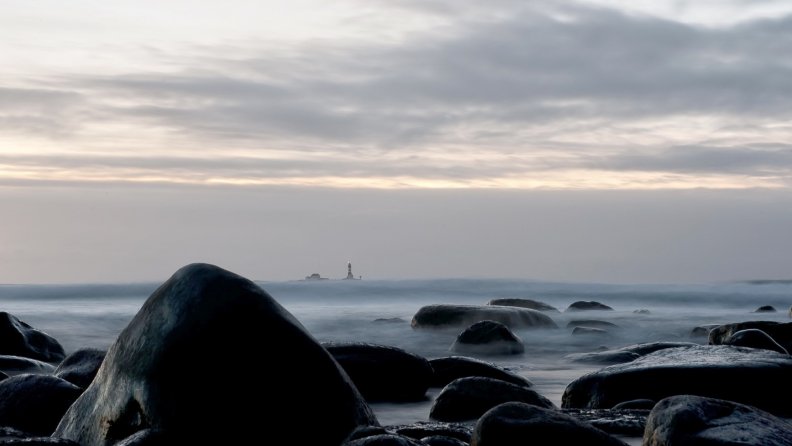lighthouse off a rocky seashore