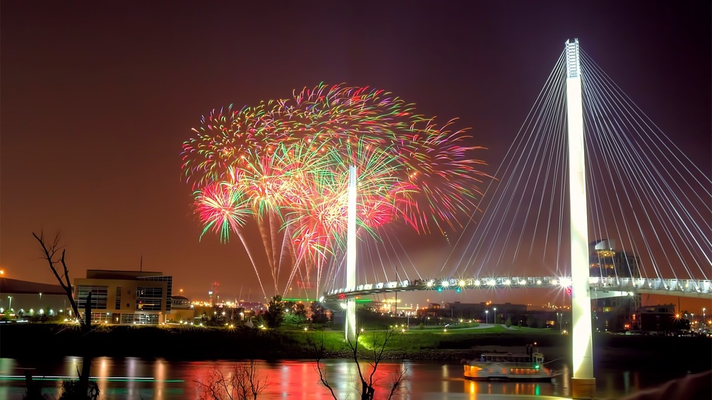 fireworks over modern pedestrian bridge