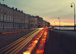 car lights on city river road at dawn