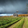barn and windmill under stormy clouds