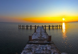 sea pier in winter at sunset