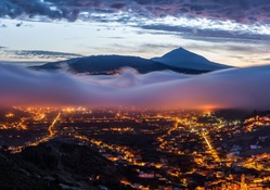 fog rising over a mountain town at dawn