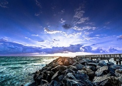 wooden pier next to stone wave breaker hdr