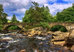 old stone bridge over rocky stream hdr