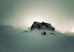 secluded cabin on a mountainside in a blizzard