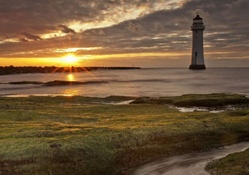 lovely lighthouse off shore at sunrise hdr
