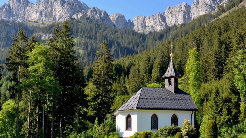 lovely_chapel_in_forest_under_grand_mountains.jpg