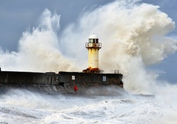 wild sea waves crashing a lighthouse pier