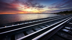 dual rail tracks along a shore at twilight
