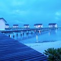 bungalows on a blue lagoon at dusk