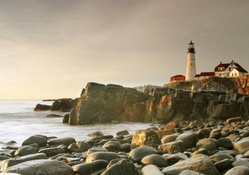 lighthouse on rough rocky shore in portland maine