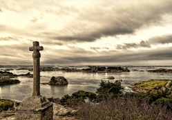large cross monument in a coastal village