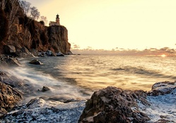 lighthouse on a fabulous rocky shore at sunset