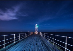 beacon at end of a pier at night