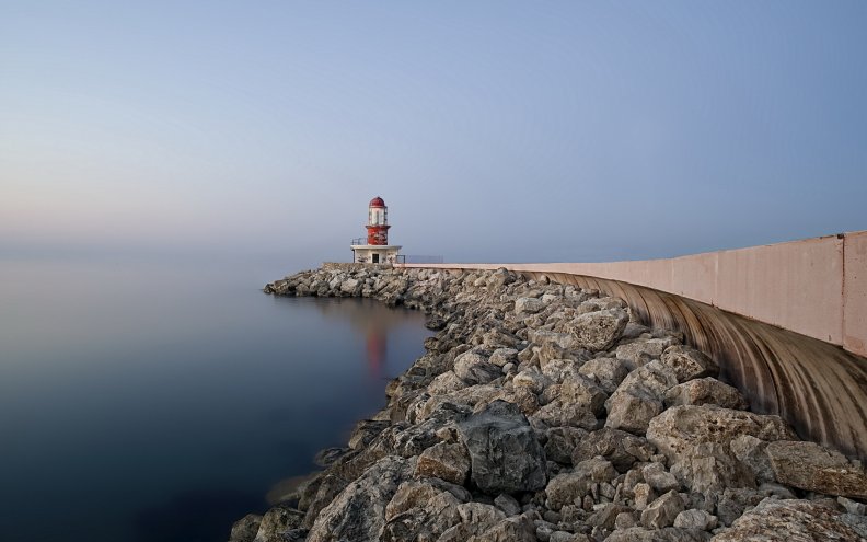 lighthouse_on_a_rock_pier_at_a_misty_sea.jpg