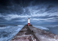 lighthouse at the end of a stone pier