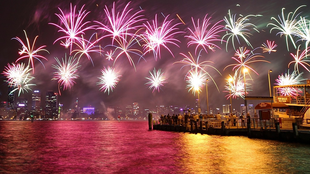fireworks above a colorful harbor