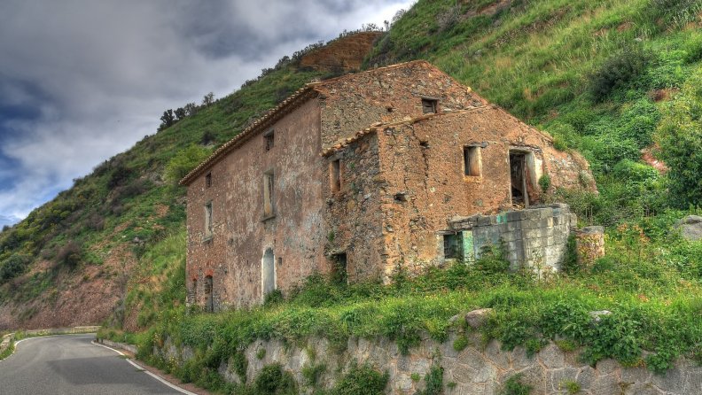 abandoned stone house by a mountain road