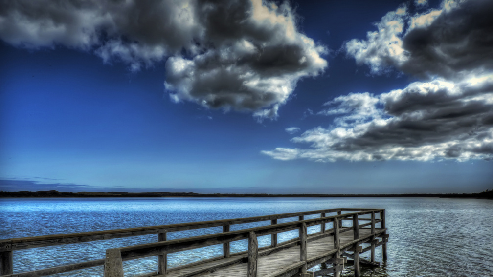 wooden pier in a blue lake hdr