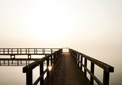 pier on beautiful foggy lake at sunrise