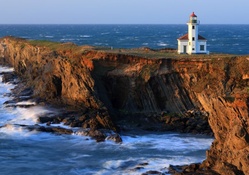 lovely lighthouse on a rocky coast point