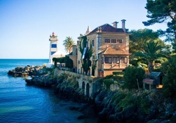mansion by a lighthouse on a rocky seacoast