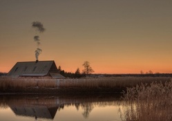 smoke from a chimney on a cabin reflected