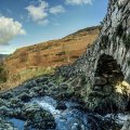 ancient stone bridge over rocky stream hdr