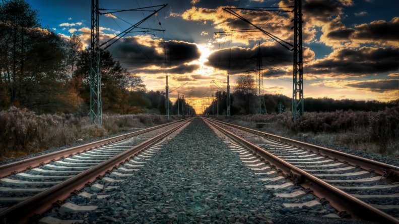 dual_train_tracks_straight_to_a_sunset.jpg