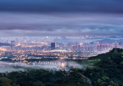 city on hills in morning fog