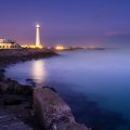 lit lighthouse at a night seashore