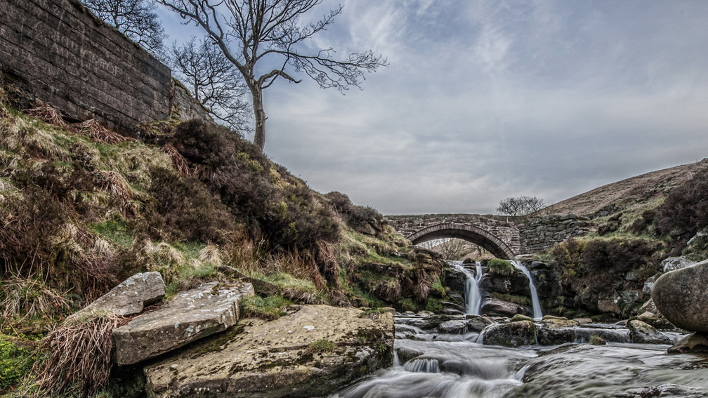 old stone bridge over beautiful rocky stream hdr