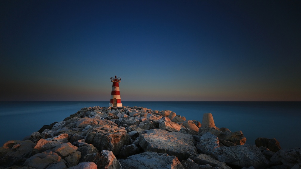 lighthouse on a stone pier in vilamoura portugal