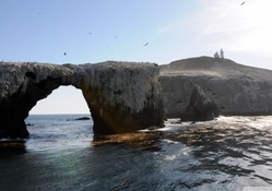 lighthouse above rock arche