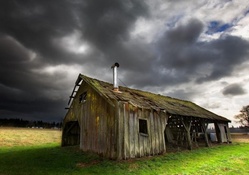 storm arriving on an old wooden cabin