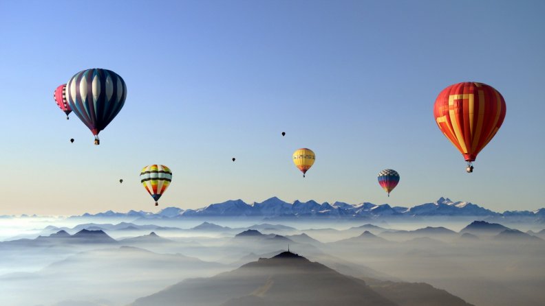 colorful hot air balloons above the clouds