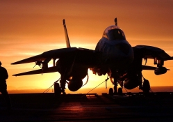 silhouette of F14 fighter on carrier at sunset