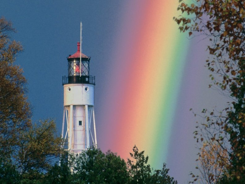 background with rainbow lighthouse at sea