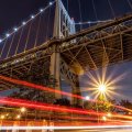 car lights under a mighty bridge