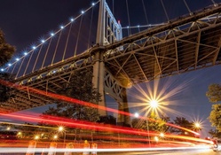 car lights under a mighty bridge