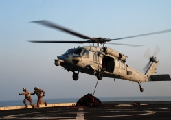 Marines run from an MH_60S after attaching cargo