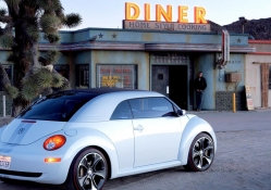 new vw beetle ragster in front of a diner