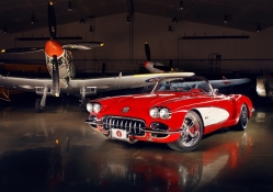 aircraft hanger and red car