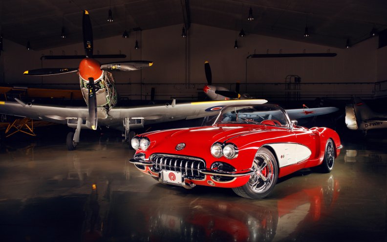 vintage_corvette_in_a_hanger_with_wwii_fighters.jpg