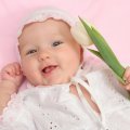 Adorable Baby Girl holding Tulip